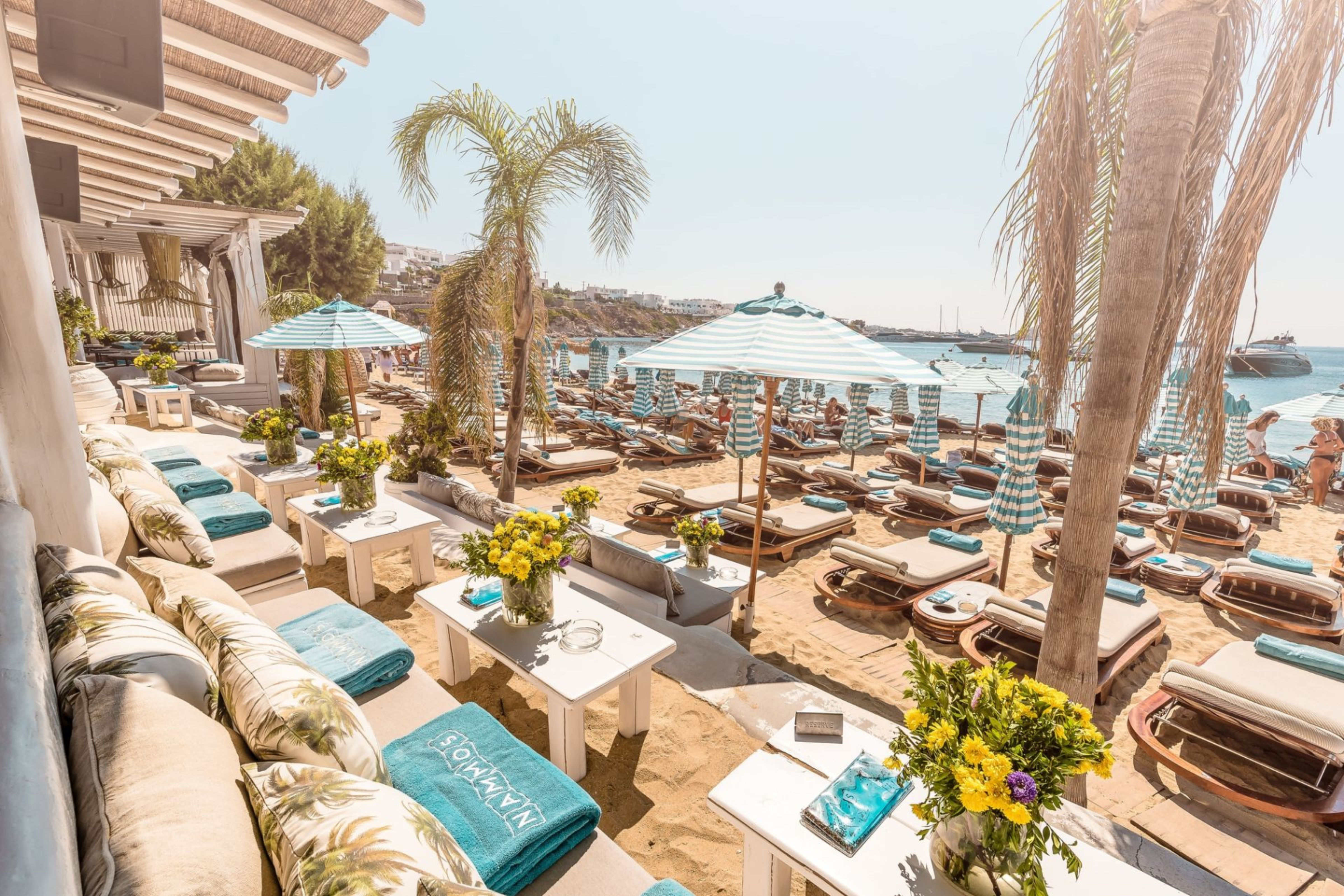 Exclusive beach clubs in Mykonos – VIP access, luxury cabanas, fine dining, refreshing cocktails, and vibrant music for a stylish seaside experience.
